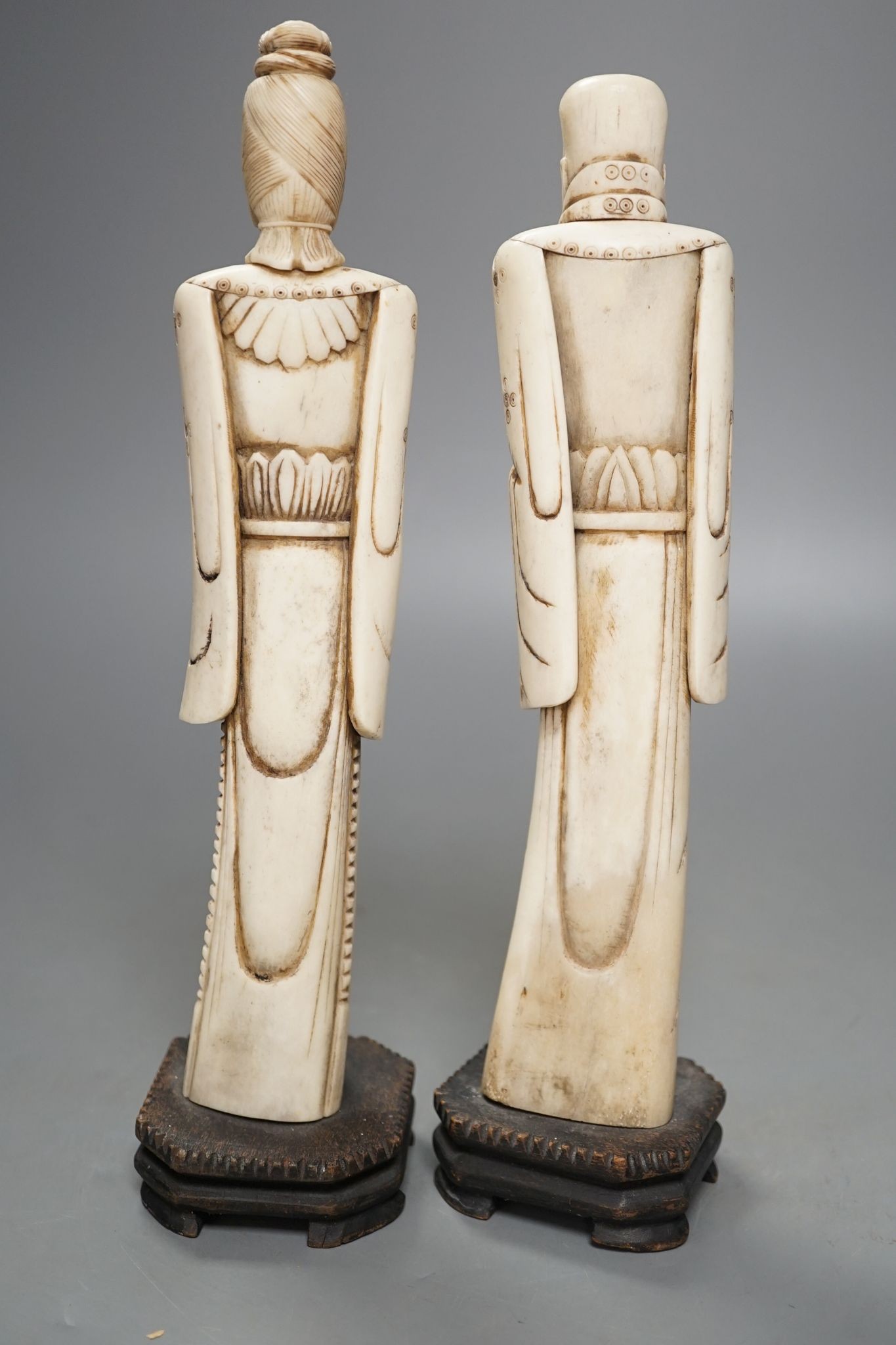 A pair of Chinese carved bone figures, Tallest 27 cms high.